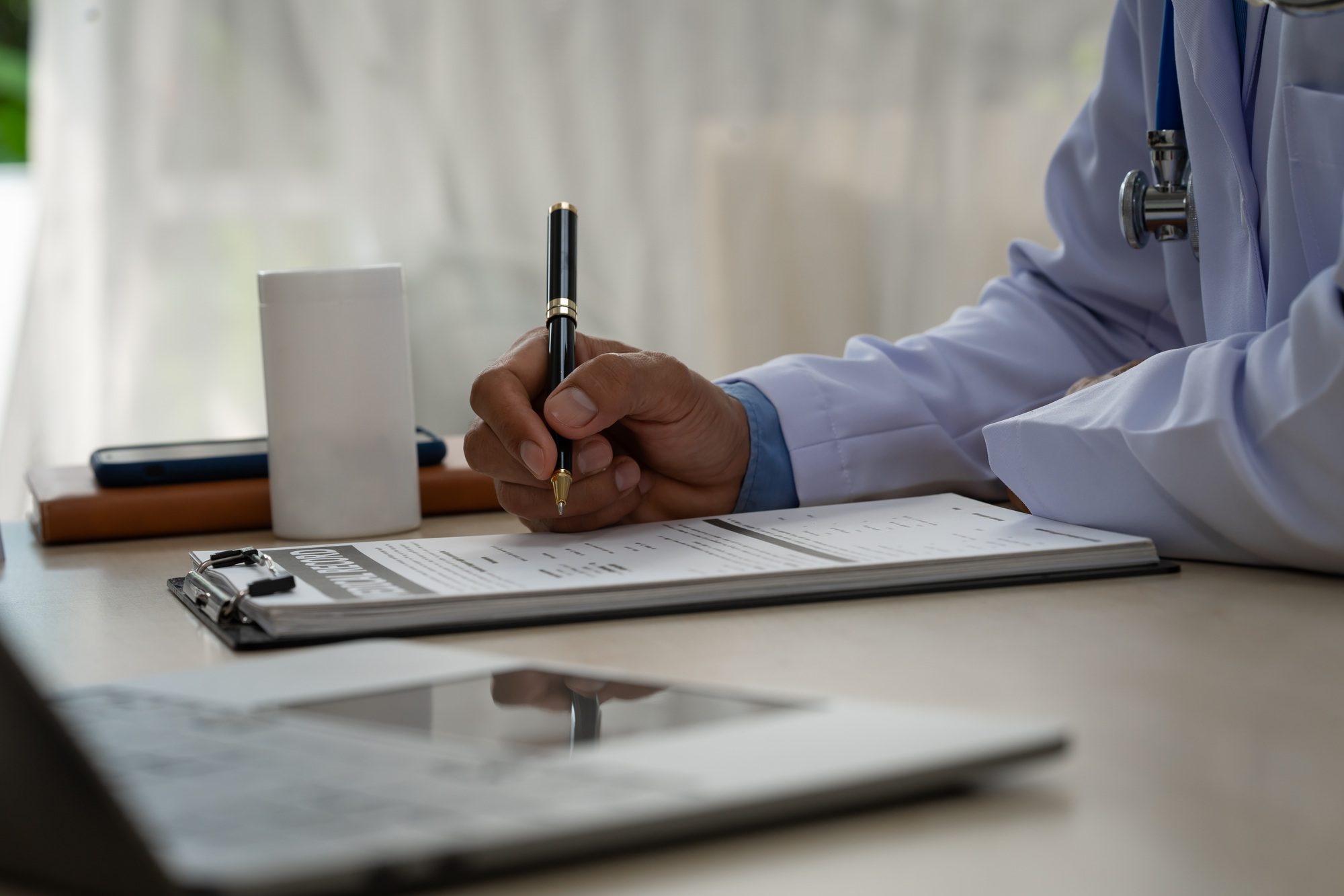 A male doctor sits at a table in a liver disease clinic, giving online advice on hepatitis