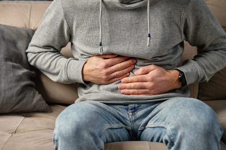 Man clutching stomach in pain. Person suffering from digestion problems